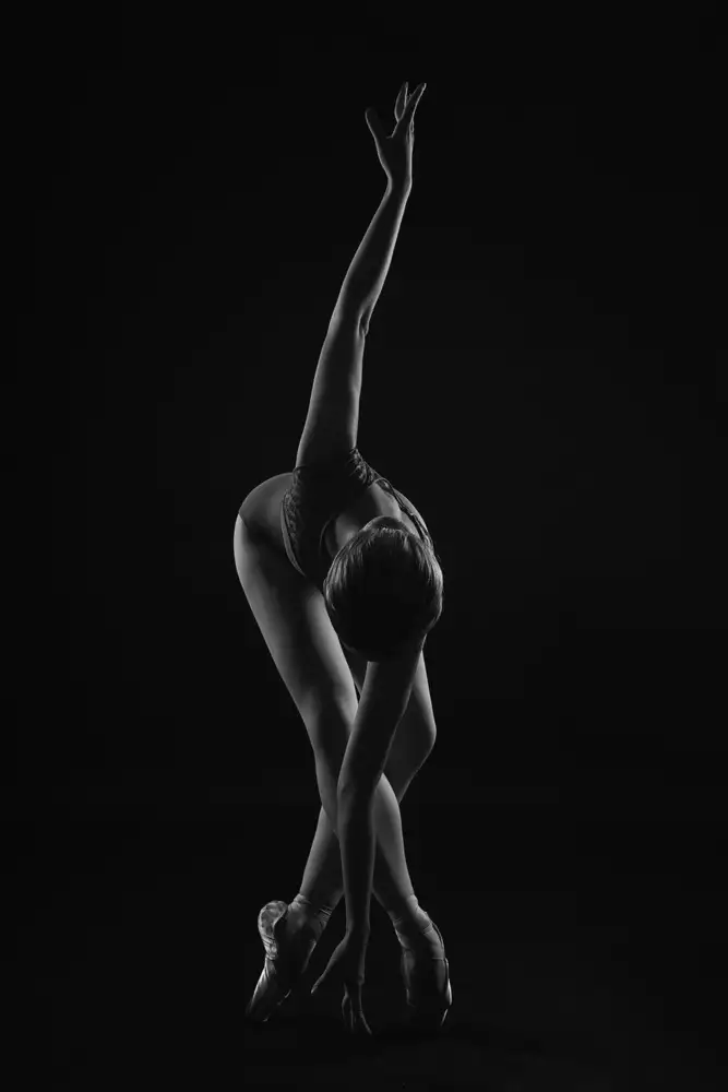 Alexandr: chaîne. la ballerine est debout sur des pointes,penchée en avant et enroulant son bras autour