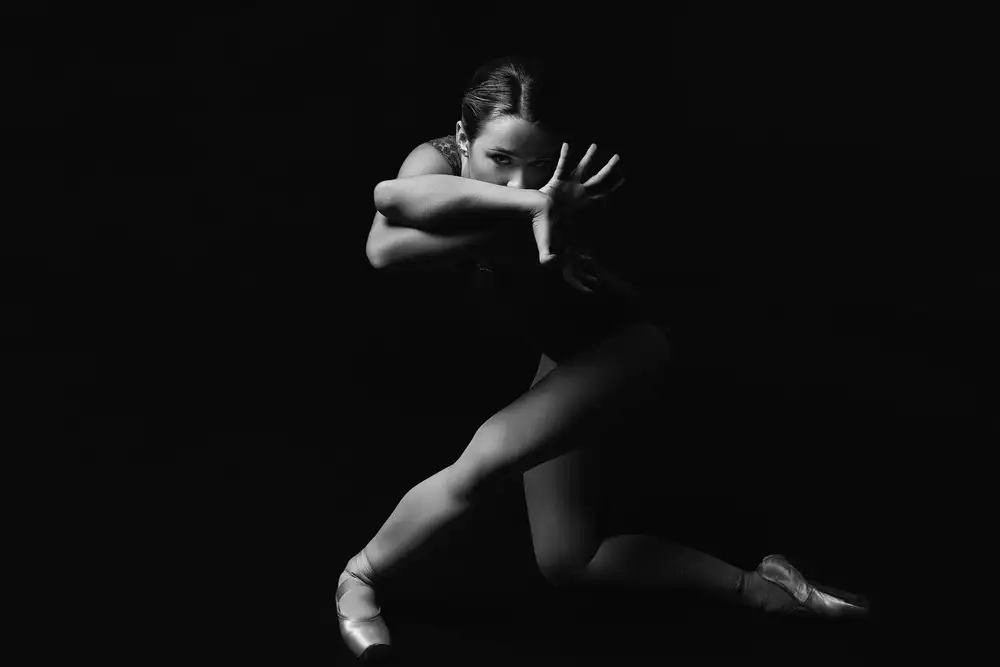 Alexandr: Prédatrice. ballerine sur pointes penchée en avant regarde à travers les bras croisés