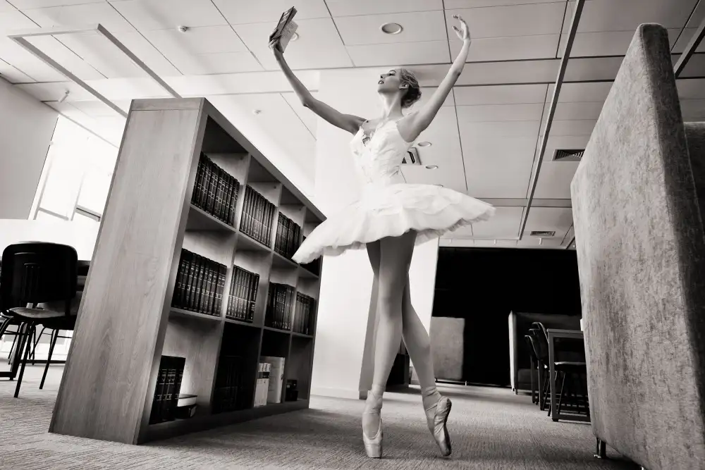 Alexandr: le rêveur. ballerine sur pointes dans la bibliothèque lit un livre le tenant