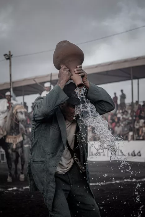 brahki, hassan El: Momento unico: un uomo che versa acqua da una bottiglia di argilla sul suo cappello dopo una carica di cavalleria unificata.