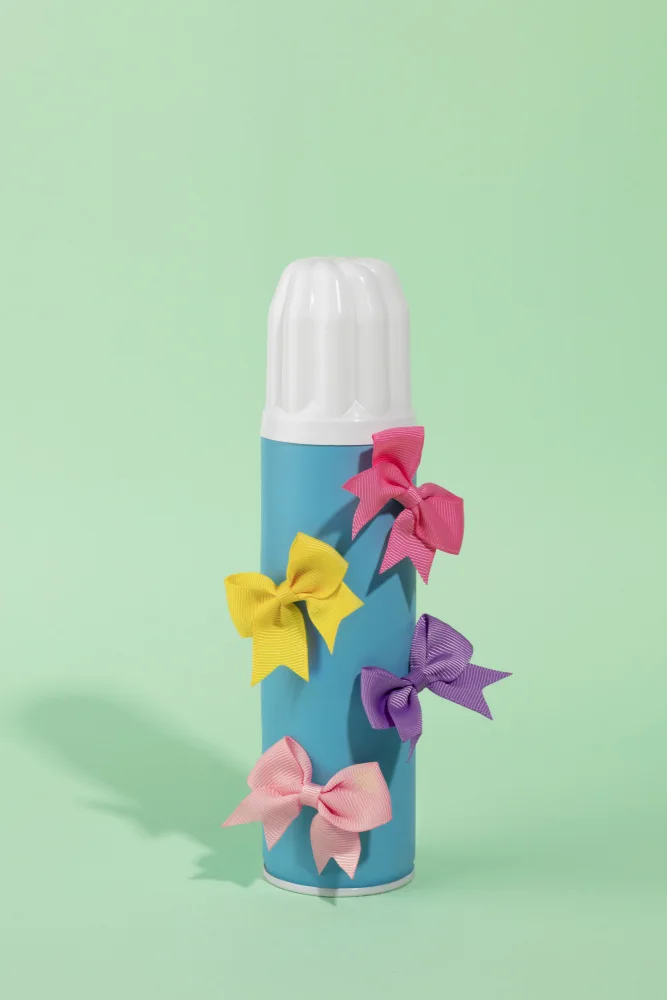 Ramiro, Julia: Botella de spray azul adornada con lazos de colores