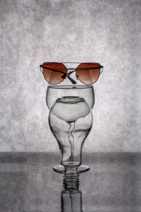 Barkow, Brig: Die Figur eines Glases und einer Sonnenbrille auf grauem Hintergrund