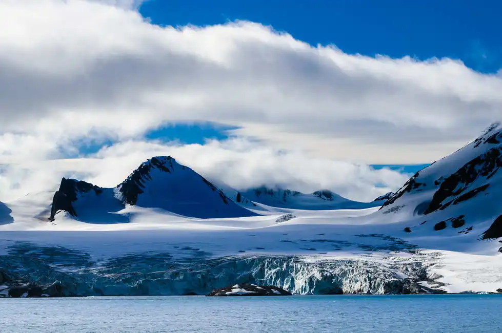 Neznámý: Ledovec míří z hor do oceánu v Hornsund, Norsko